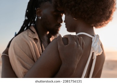 African man with dreadlocks hugging wife with Afro hair on coast during honeymoon on sunny summer day - Powered by Shutterstock