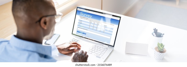 African Man Filling Online Survey Form On Laptop Computer - Shutterstock ID 2156076489