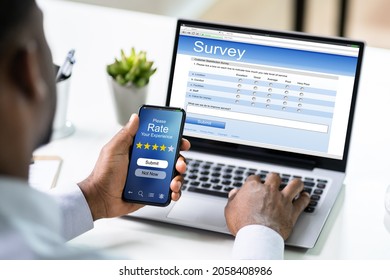 African Man Filling Survey Poll Or Form On Laptop Computer