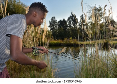 African Man Fishing At Small Dam At Home During Lock Down