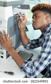 African Man Fixing Photo Copier