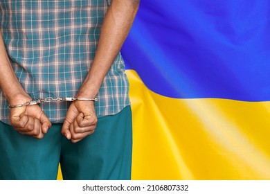 African Man With Handcuffs On The Background Of The Ukraine Flag. Back View. Concept Of Prisons And Corruption In Ukraine