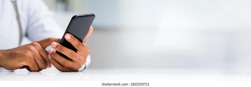 African Man Holding Smartphone Or Mobile Phone - Powered by Shutterstock