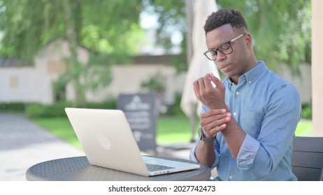 African Man With Laptop Having Wrist Pain, Sitting Outdoor