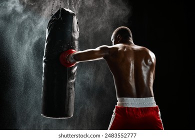 African man, muscular fighter in mid-punch, showcasing his training routine isolated on black background. Concept of professional sport, active lifestyle, body, strength - Powered by Shutterstock