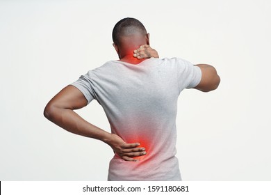 African man with neck and back pain, rubbing his painful body over white background, back view