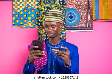 African Man Online Banking With A Credit Card And Mobile Phone