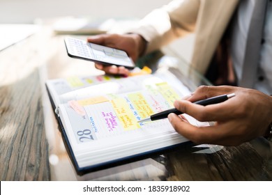 African Man Organizing Appointment Calendar Schedule Using Cellphone