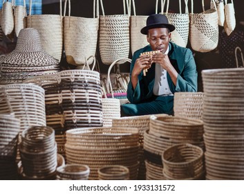 African Man Playing Panpipe, Selling  Traditional Straw Basketry In South Africa, Durban Market. 