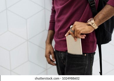 African man putting mobile phone on his pocket