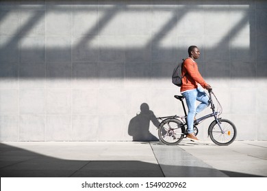 African Man Riding Folding Bike For Urban Commuting