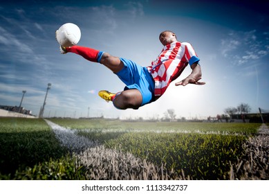 African Man Soccer Player Hitting The Ball.
