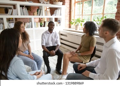 African man speaking at group counseling therapy session looking for support in addiction treatment, black guy talking sharing problem sitting in circle among diverse friends listening understanding