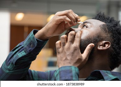 African Man Using Eye Drop, Eye Lubricant To Treat Dry Eye Or Optical Allergy