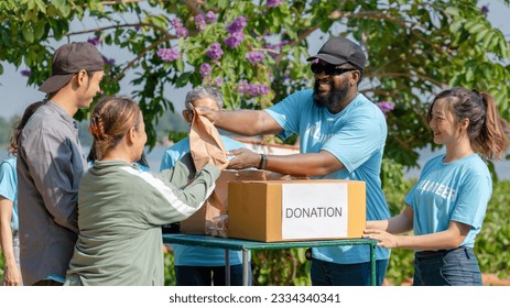 African man volunteer give some food in paper bag to poor people, raising money through donation box charitable working together to help people by donate food, clothing, support education environment - Powered by Shutterstock