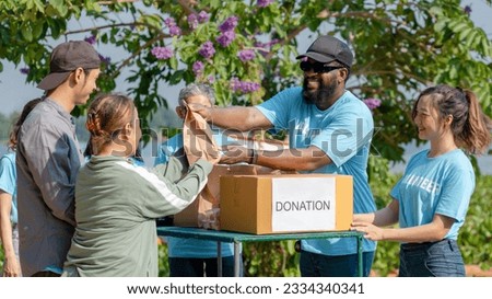 African man volunteer give some food in paper bag to poor people, raising money through donation box charitable working together to help people by donate food, clothing, support education environment