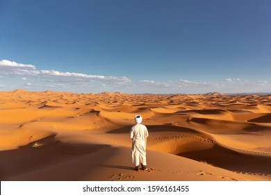 African Man Waching Brilliant Blue Of The Sky Meets The Gold Of The Dunes Of The African Desert, Sahara