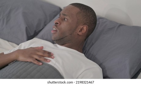 African Man Waking Up From Nightmare In Bed