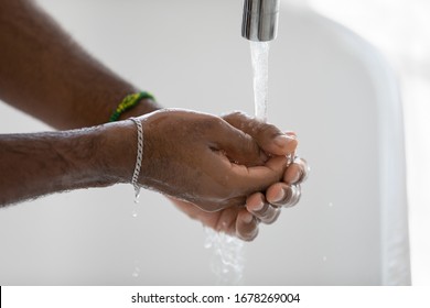 African man washing his hands under flowing water standing in bathroom at home close up image. Concept of personal anti bacterial hygiene, infectious disease prevention, anti COVID19 stop corona virus