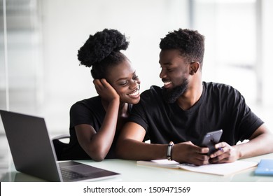 African man and woman look at phone in office - Shutterstock ID 1509471569