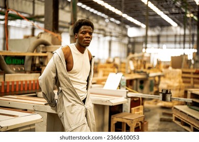 African man workers engineering standing with confidence with working suite dress and hand glove in front machine. Concept of smart industry worker operating. Wood factory produce wood palate.