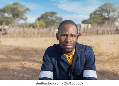 african man in workwear , in the village, standing in front of the kraal with small livestock - Powered by Shutterstock