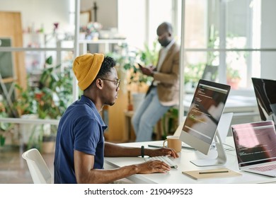 African man writing code on new software