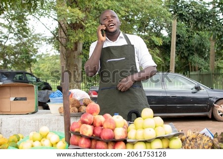 african market seller using his phone