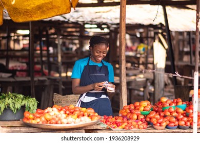 African Market Woman Smiling While Counting Money