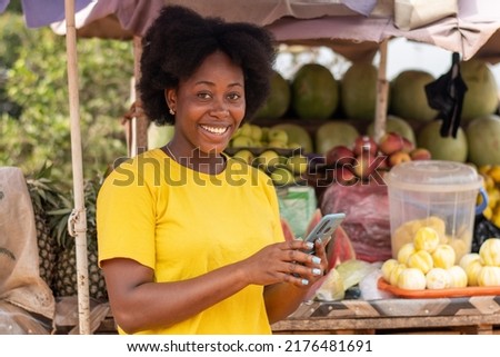 african market woman using her phone smiling