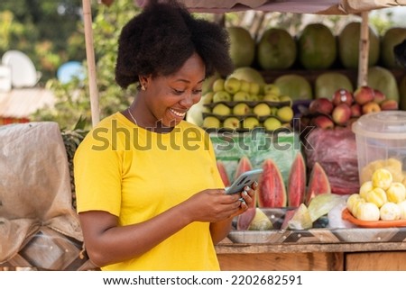 african market woman using her phone to text
