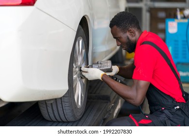 African Mechanic Working In The Garage.