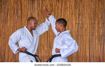 African Men Performing Kumite At A Dojo On A Blue Floor