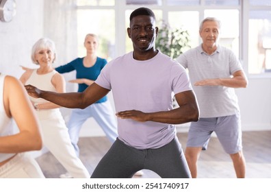 African middle aged man and mature students are engaged in dance class or fitness room with active jazz music. Hobby, healthy lifestyle concept - Powered by Shutterstock