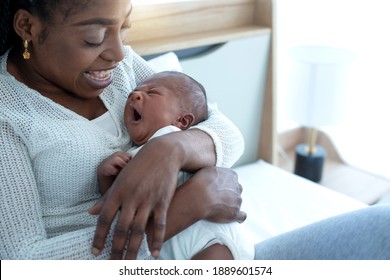 African mom carried and was expressing affection for her 21 days baby boy, baby is yawning, mother and little kid relaxing at home
