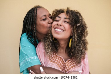 African mother kissing and hugging her adult daughter outdoor - Family, mother and child love