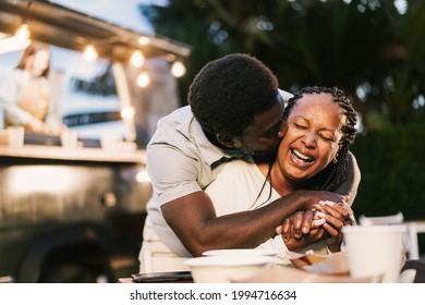 African mother and son having fun together outdoor at food truck restaurant - Love and family lifestyle concept - Focus on mum face