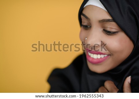 african muslim woman with a beautiful smile takes a selfie with a cell phone