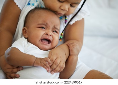 African Newborn Baby Crying And Her Sister Soothing To Stop Crying On Bed