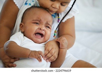 African Newborn Baby Crying And Her Sister Soothing To Stop Crying On Bed