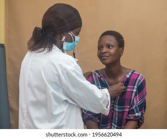 An African Nigerian Female Doctor With Nose Mask And Stethoscope Checking Out A Female Patient