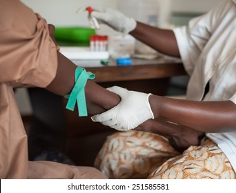 African nurse is drawing blood from an African male for blood tests. 