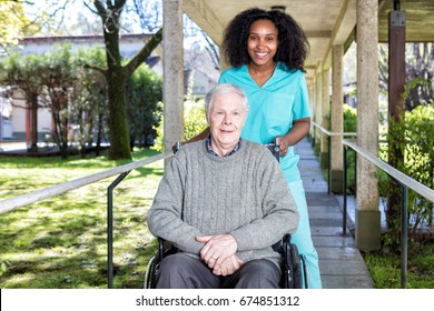 African nurse helping man on the wheelchair.