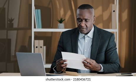 African Old Man Senior Mature Male In Office Opening Paper Envelope Reading Letter With Good News. Happy Elder Retired Businessman Received Investment Notification Banking Loan Approval Salary Bonus