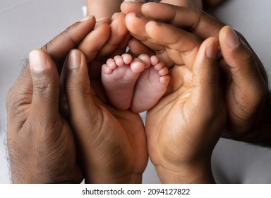 African parents holding the feet on a new born baby - Powered by Shutterstock