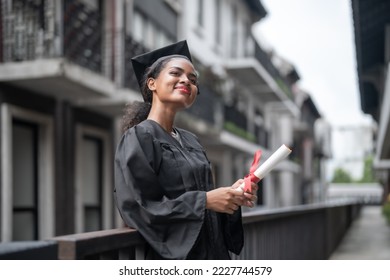 African people students man and woman with black graduation gowns hold the diploma and stand together. With the feeling of happy and graceful. - Shutterstock ID 2227744579
