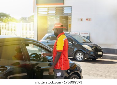 African Petrol Attendant Checking Temperature Of The Driver With An Infrared Thermometer At A Gas Station In Botswana