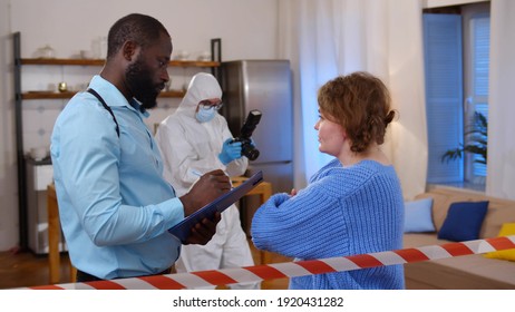 African Policeman Interrogating Woman Witness At Crime Scene. Side View Of Afro-american Detective Writing Down Witness Testimony Investigating Murder