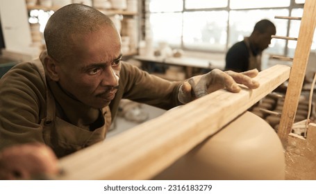 African potter checking the level of a bowl in a ceramics studio - Powered by Shutterstock