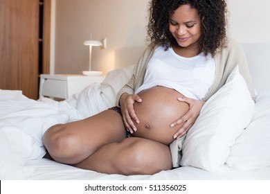 African Pregnant woman touching her 39 weeks belly